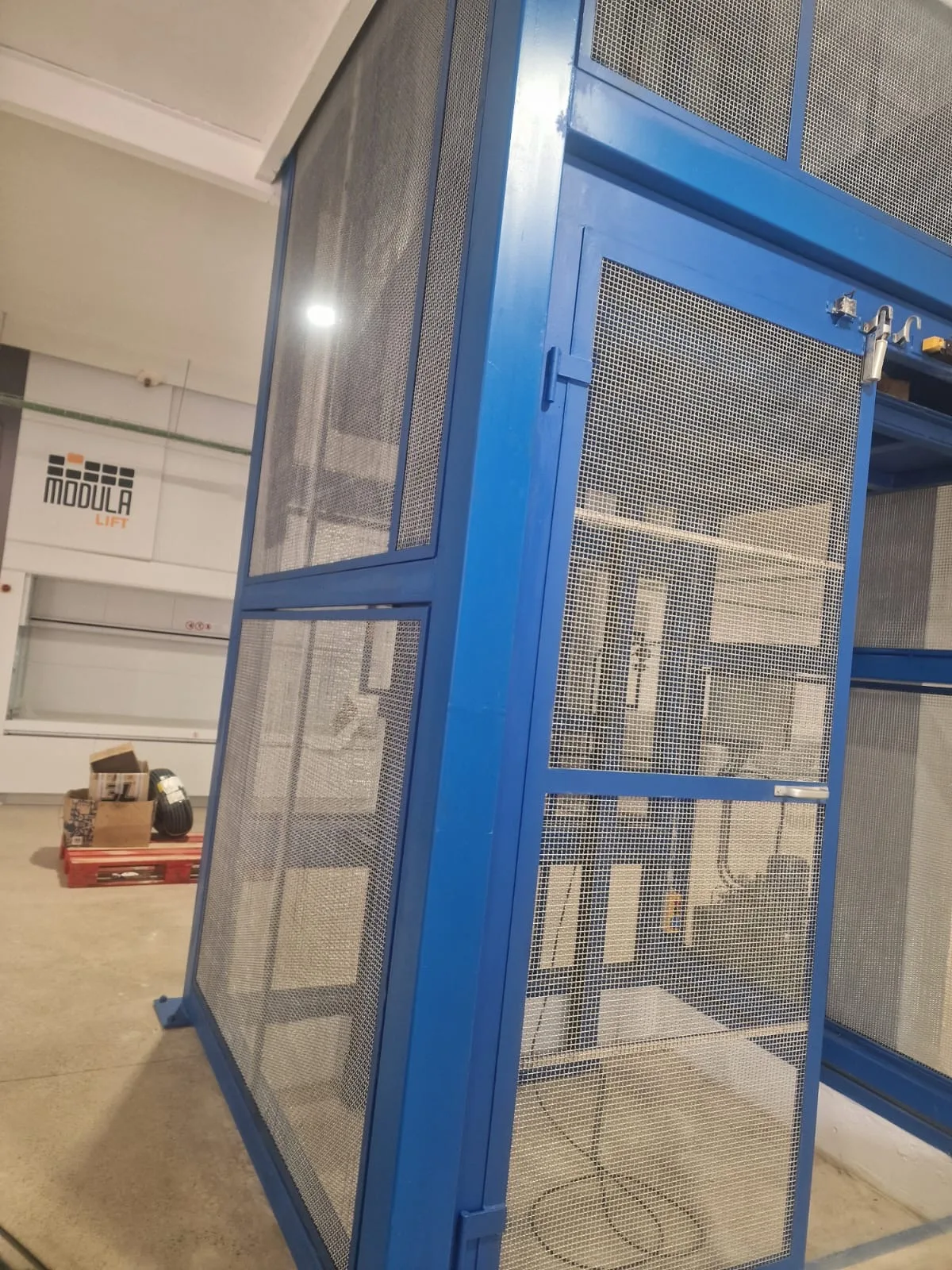 Cabina de montacargas azul en nave industrial de Barcelona