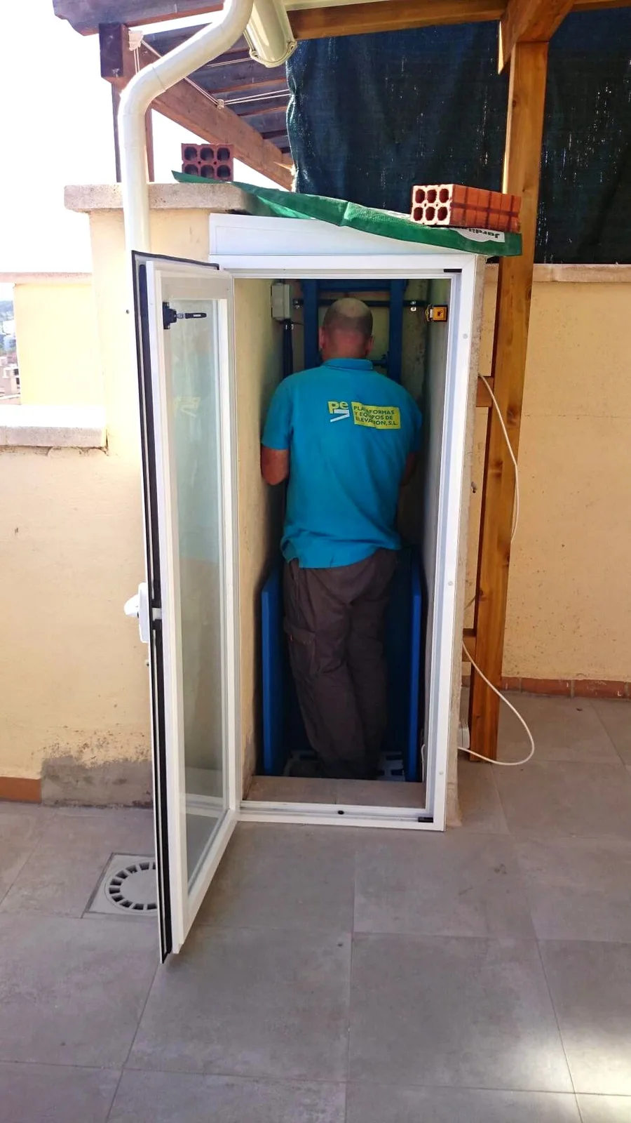 Técnico de Plataformas y Elevación instalando un salvaescaleras en comunidad de vecinos
