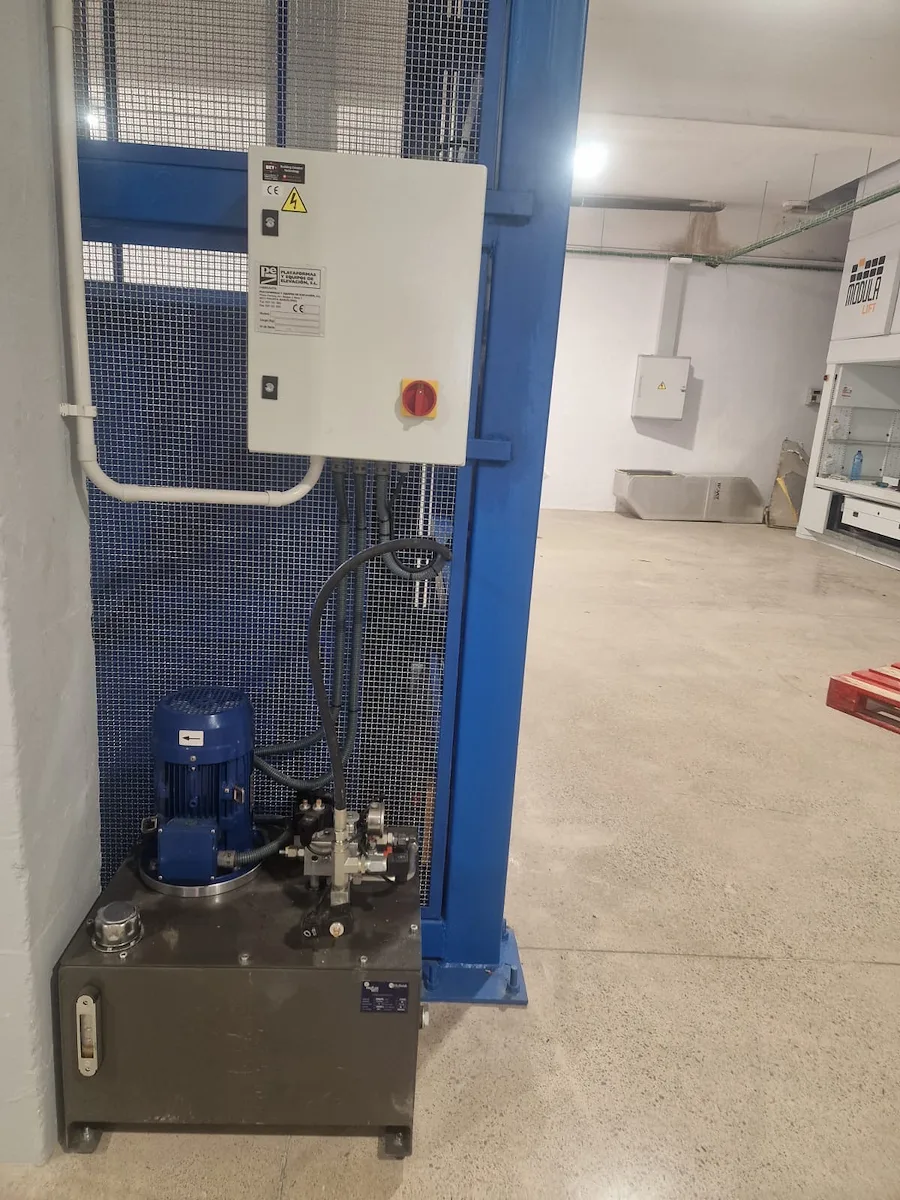 Grupo hidráulico y cuadro de maniobra instalados junto al hueco de un montacargas