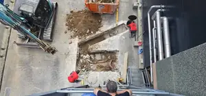 Excavación del foso de un montacargas en obra, vista desde arriba, con operarios trabajando