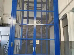 Puertas de dos hojas de un montacargas de gran altura con marco azul
