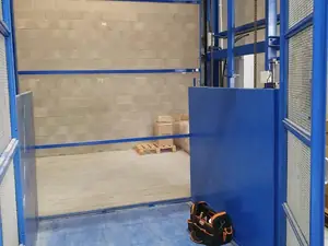 Plataforma de un montacargas junto a una pared de bloques, con una bolsa de herramientas en el suelo
