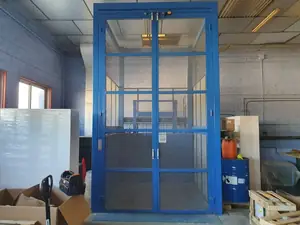 Puertas de dos hojas de un montacargas de malla azul dentro de un edificio