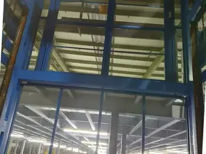 Estructura de un montacargas de malla azul vista desde abajo, con la nave al fondo