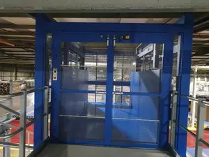 Montacargas de malla azul con puertas de dos hojas en una planta de almacén