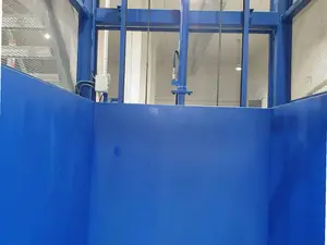 Interior de la plataforma de un montacargas con los laterales de chapa azul