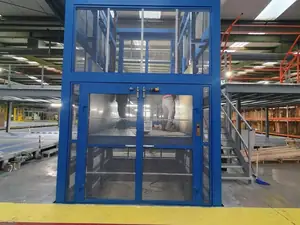 Montacargas de dos plantas con puertas de malla en una nave con escalera