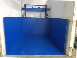 Plataforma de chapa azul de un montacargas en un hueco de paredes blancas