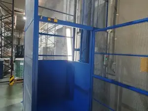 Montacargas de malla azul con las puertas abiertas en un almacén